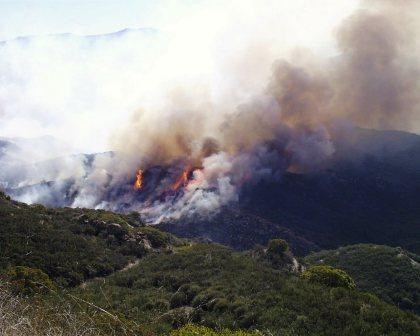 Wildfire can destroy many acres of parkland when conditions are just right. This fire is burning very quickly up a hillside.