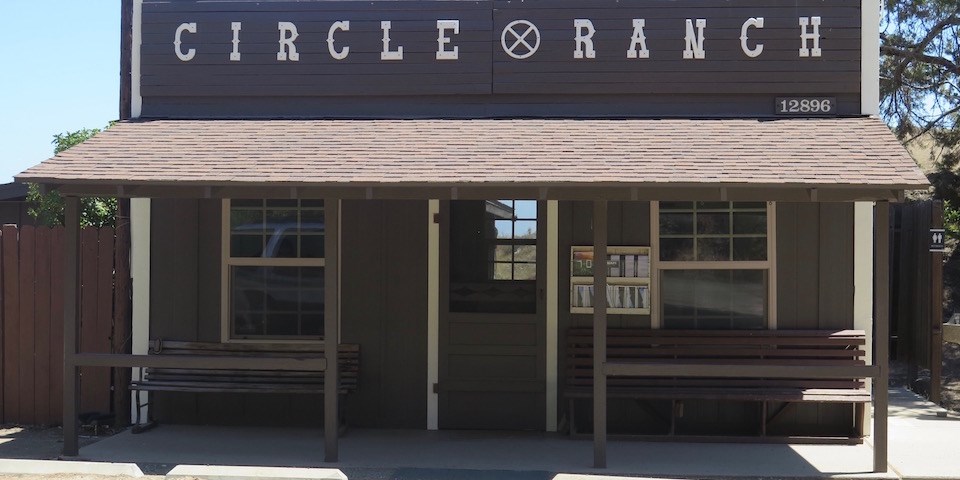 A small brown ranger station labeled Circle X on top with a few parking spots in front