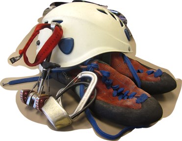 A climbers helmet, hardware, and shoes are ready for a day of climbing.