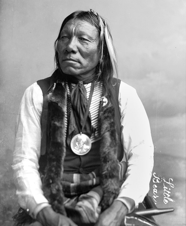 Photographed here in 1891 in Washington, D.C., Little Bear barely survived the Sand Creek Massacre. A federally-issued peace medal hangs from his neck.