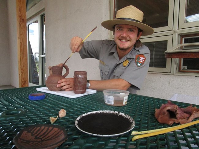 Ranger Davis slipping a pot with a Yucca brush. Ranger Davis slipping a pot with a Yucca brush.