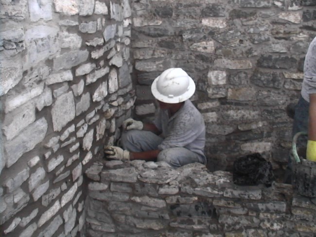 Student Employee stabilizing a wall at Gran Quivira.