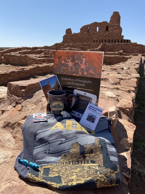 Souvenirs from the bookstore are arranged in front of the ruins of a red sandstone church.