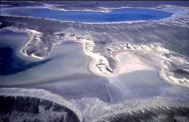 An aerial view of the Estancia Basin showing a shallow lake and salt deposits. An aerial view of the Estancia Basin showing a shallow lake and salt deposits.