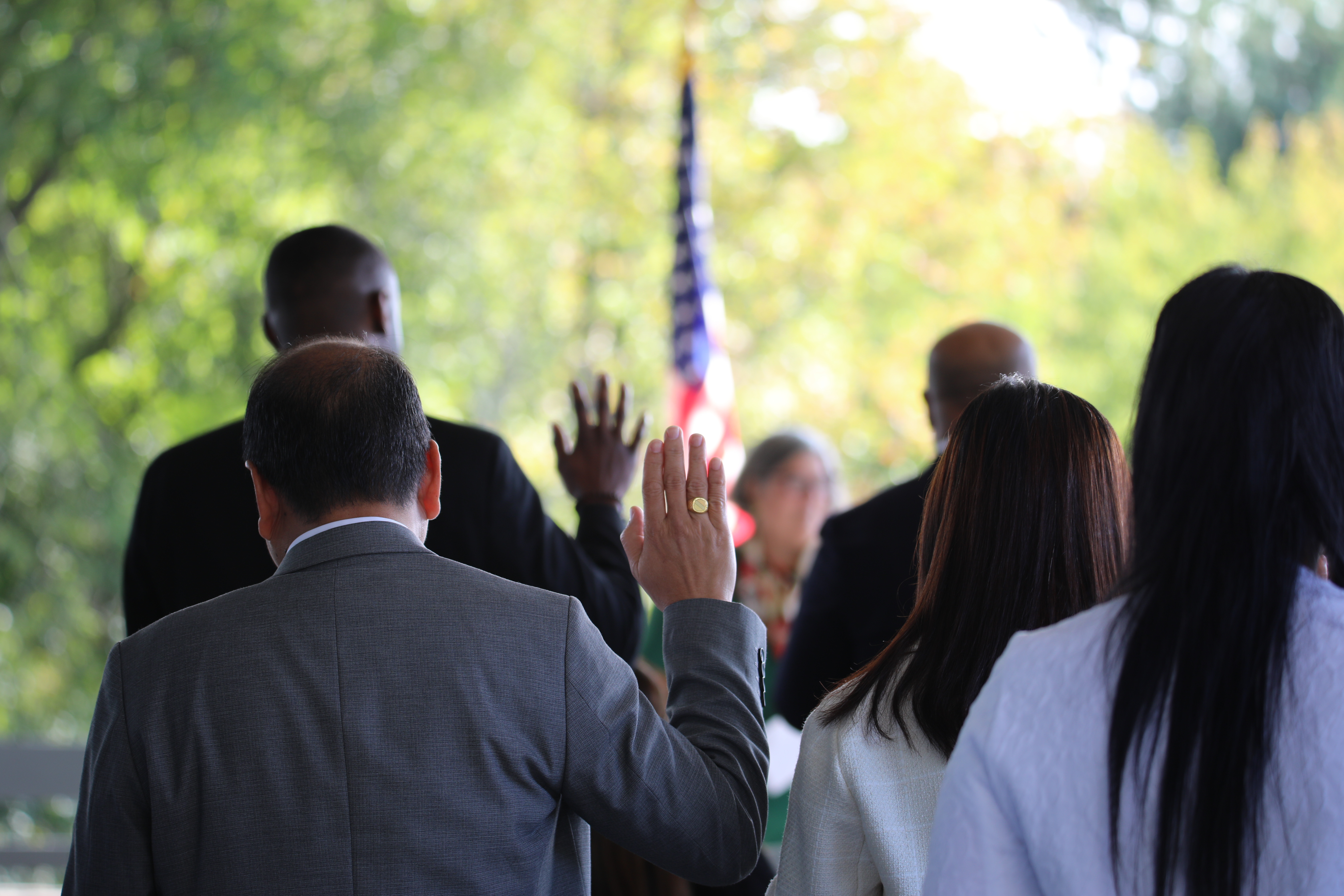 People raise their hands to be sworn in as American citizens.