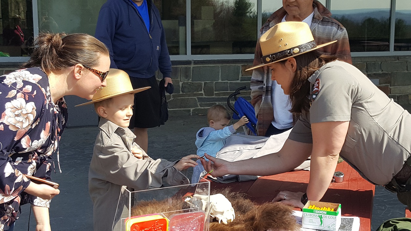 Park Ranger gives badge to new Junior Ranger on Junior Ranger Day Junior Ranger Day Saratoga NHP