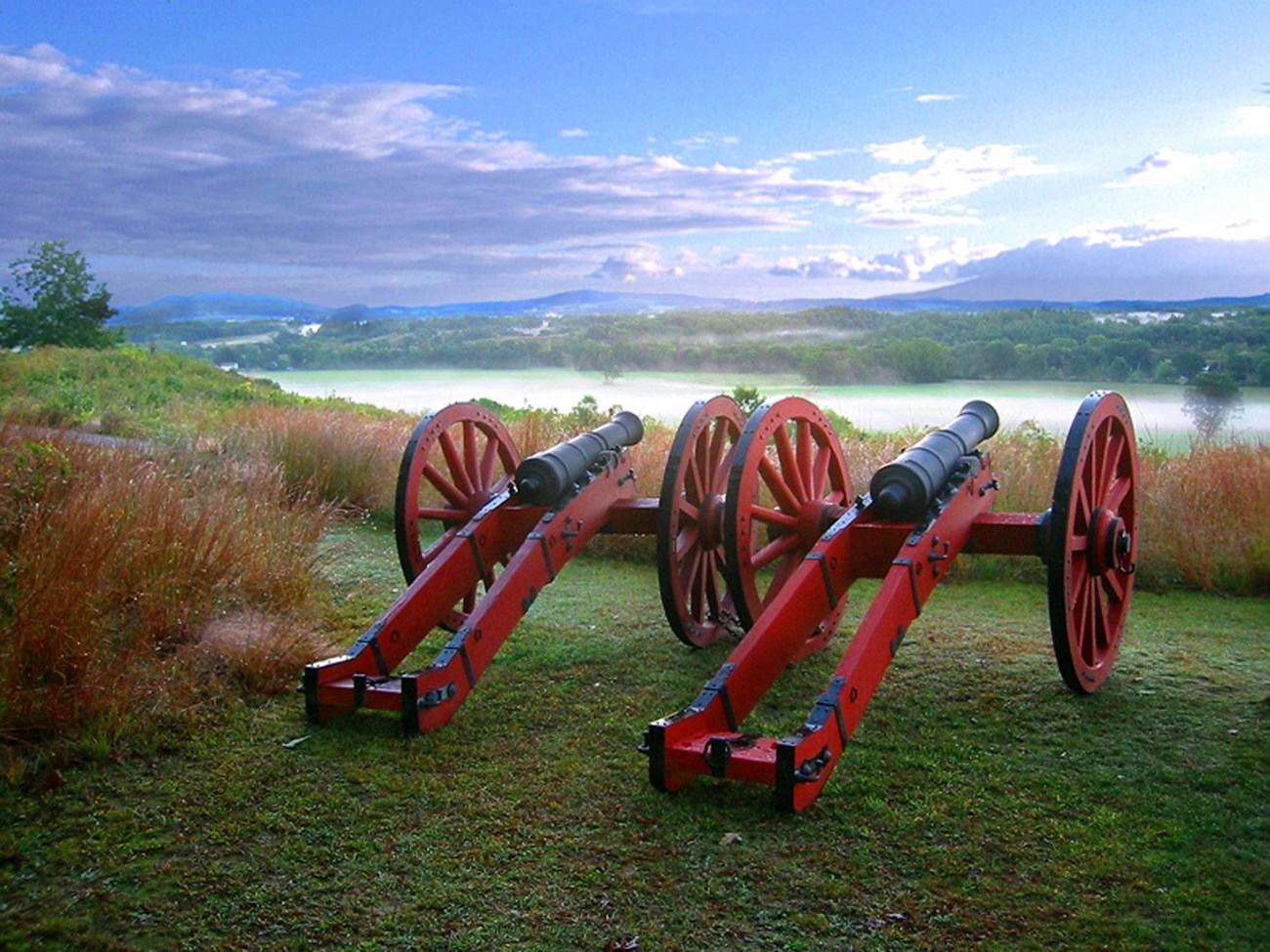 Two Red canons overlooking a misty hudson river valley