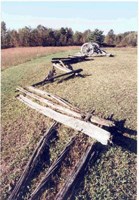 A mown field features a collapsed wooden A mown field features a collapsed wooden