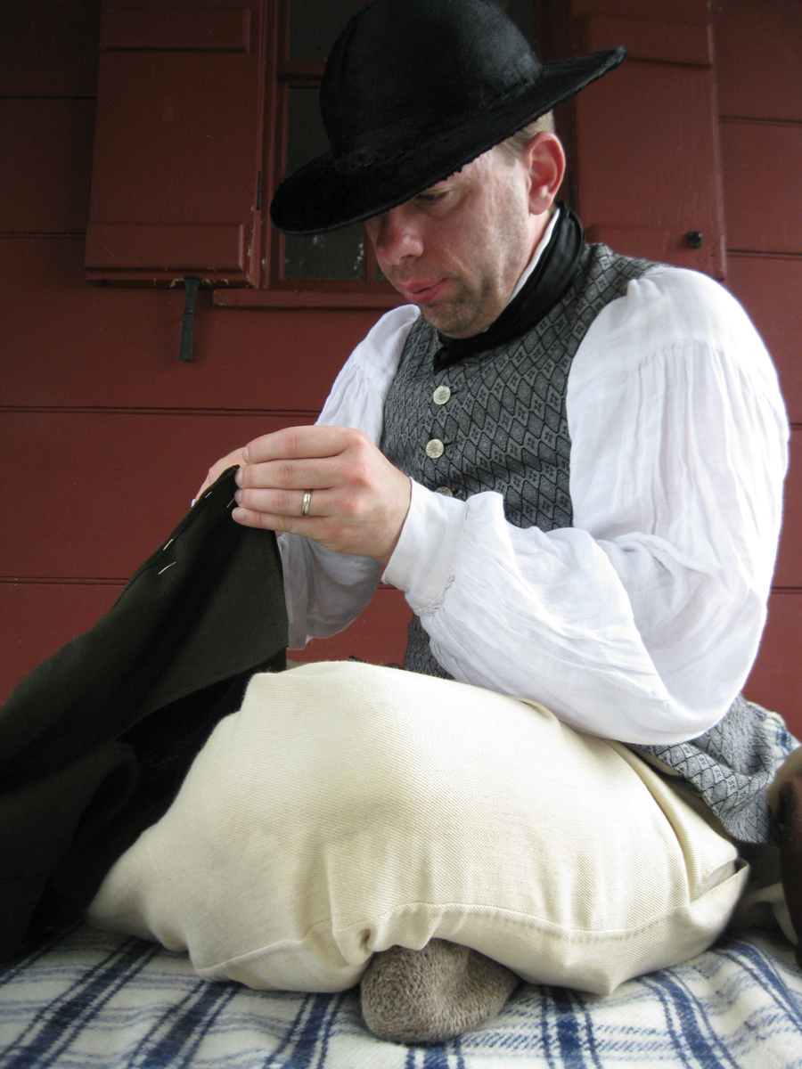 Colonial man sitting on porch sewing Colonial man sitting on porch sewing