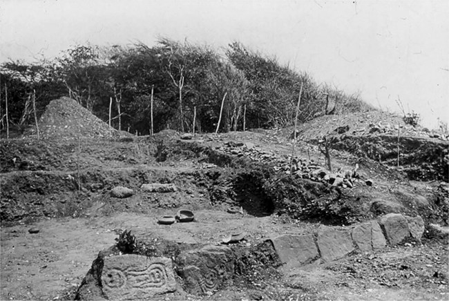 historic photograph of the archeological excavations and the ballcourt stones, 1922