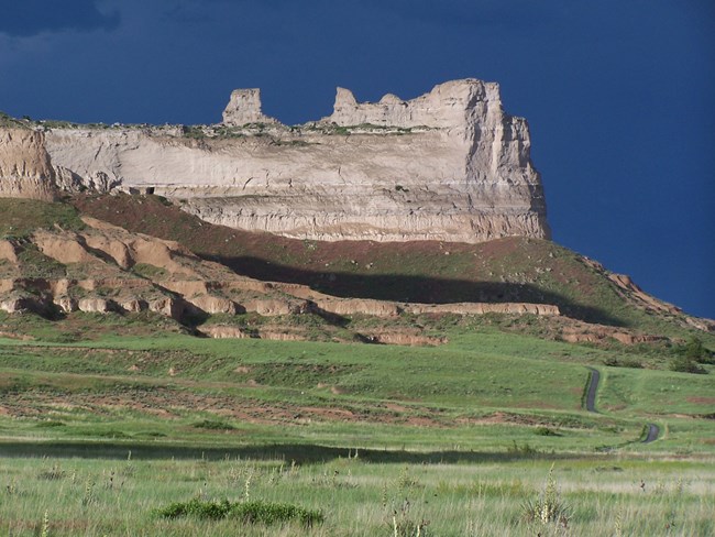 A sandstone formation extends out onto the prairie.