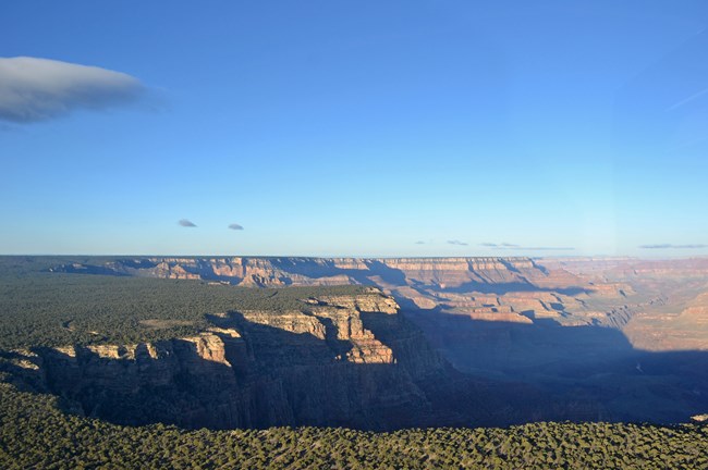 A large canyon at the edge of a flat plateau.