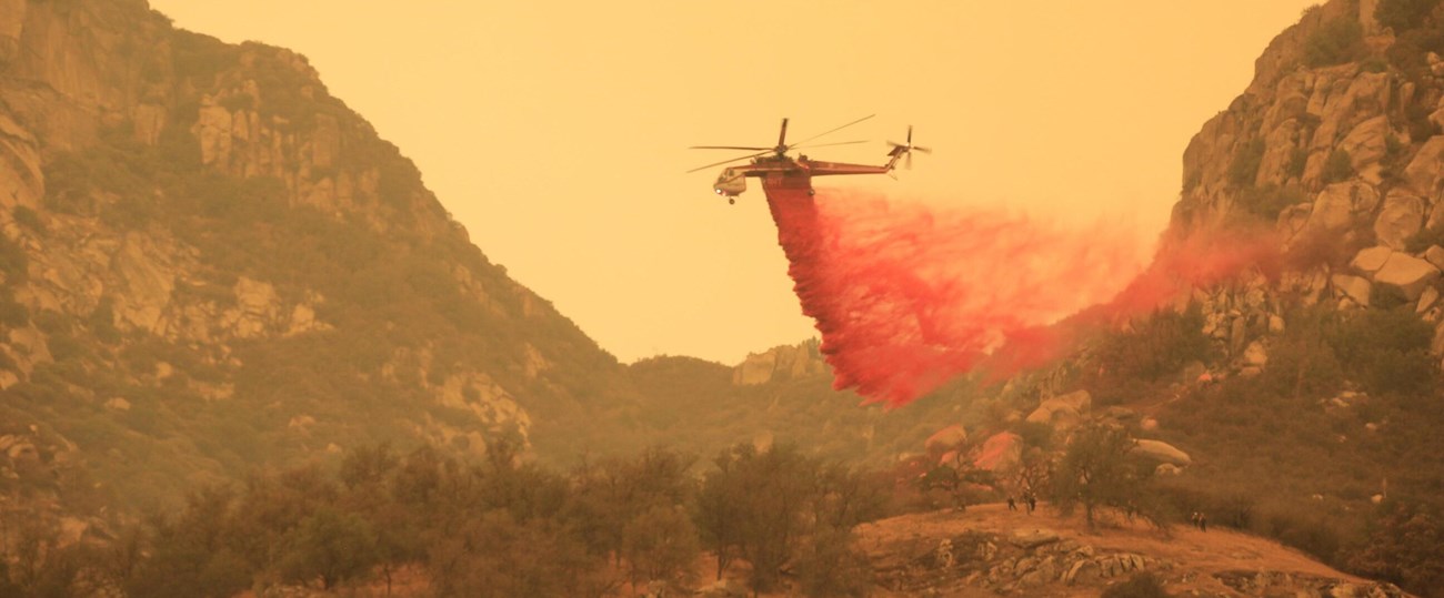 Helicopter drops fire retardant on oak woodlands and shrublands in the foothills of Sequoia National Park to reduce vegetation flammability as fire approaches, September 26, 2021.