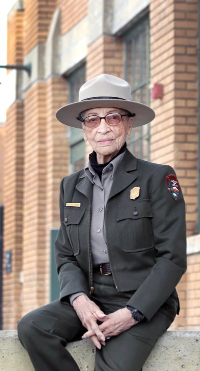 An elderly woman in uniform poses for the camera.