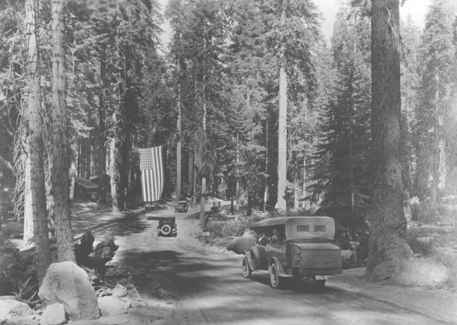 early automobiles drive on park roads