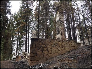 View of masonry chimney and base = all that is left of a historic ranger station after a fire.