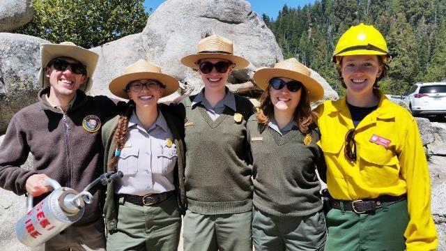 A fire information officer, park rangers, and a volunteer help share information during a prescribed burn.