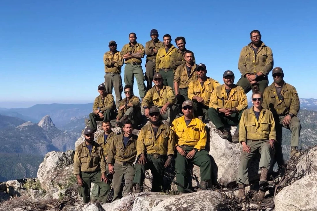 The Arrowhead Hotshots pose on a granite mountaintop 19 hotshots pose on a rugged mountaintop
