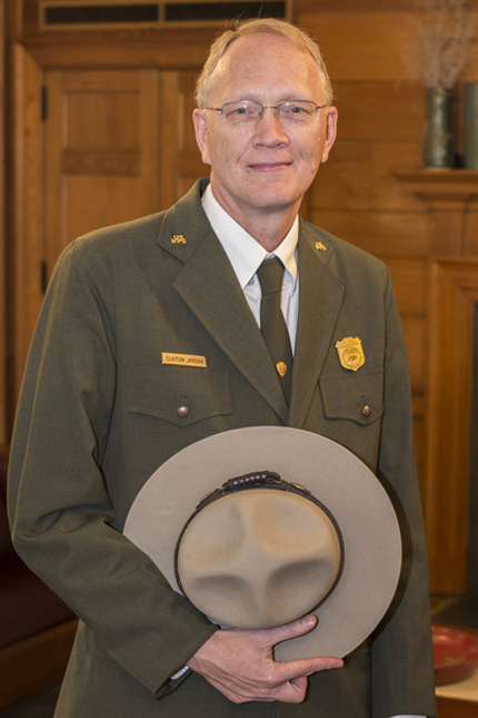 Superintendent Clay Jordan in NPS service dress uniform, holding his flat hat.