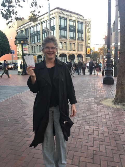 Photo of Mrs. Gomez holding up tickets and smiling