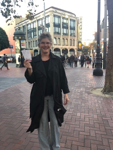 Mrs. Gomez Photo of Mrs. Gomez holding up tickets and smiling