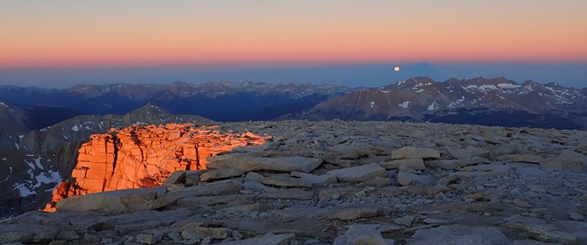 A sunset over a vast mountain range.