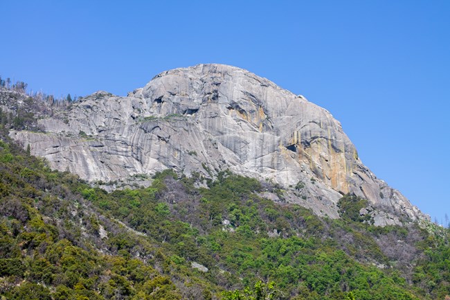 A large granite dome against a blue sky.