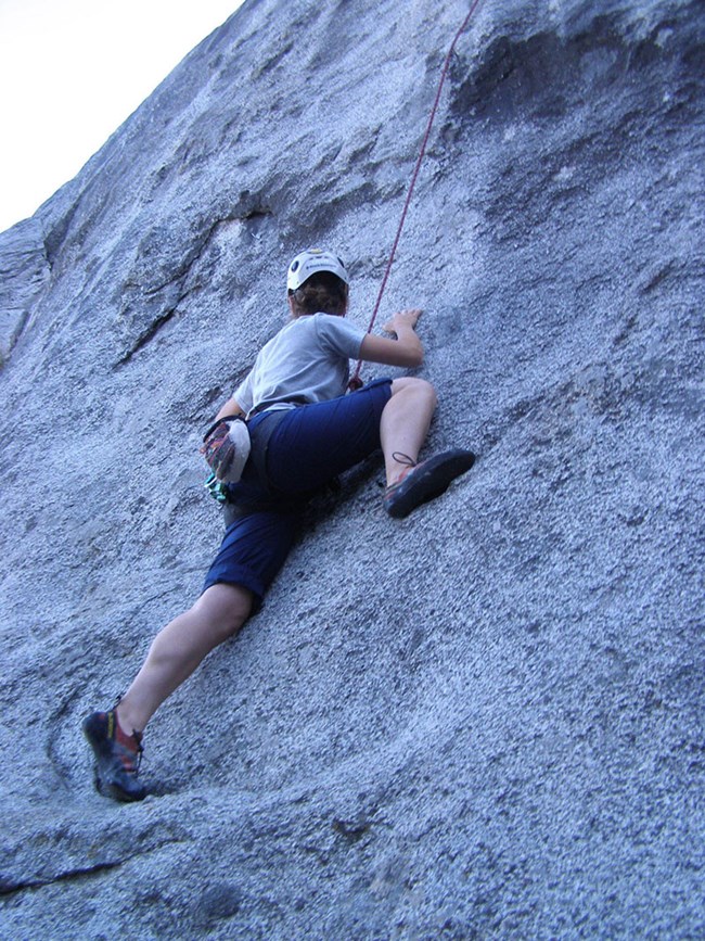 A climber scales a rock face.