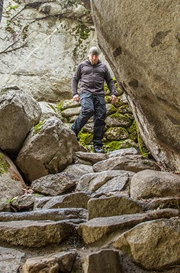 A man walks down a steep stone stairway A man walks down a steep stone stairway