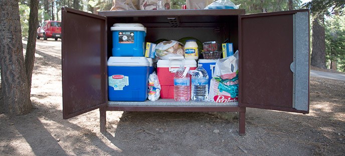 A metal food-storage box packed with coolers and food