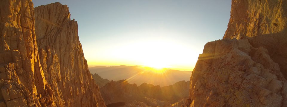 A sunrise lights up rocky peaks