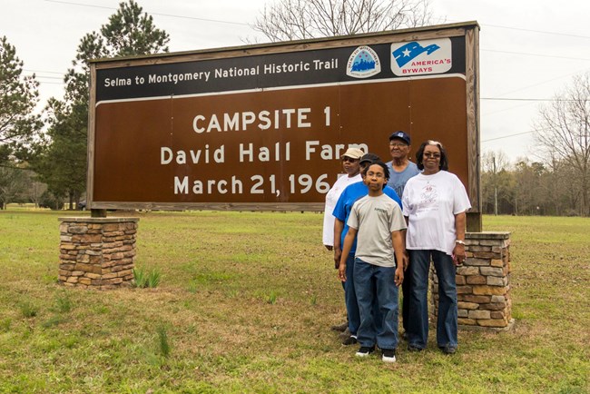 The Hall Family pose in front of the trail sign marking the site of the marchers first campsite on the way to Montgomery in 1965