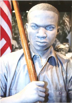 Sculpture representing a marcher carrying an American flag located in the Lowndes Interpretive Center