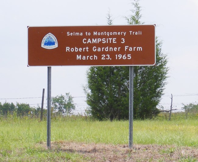 NPS road sign dedicated to the third campsite during the Selma to Montgomery march that reads "Selma to Montgomery Historic Trail, Campsite 3, Rpbert Gardner Farm, March 23, 1965"