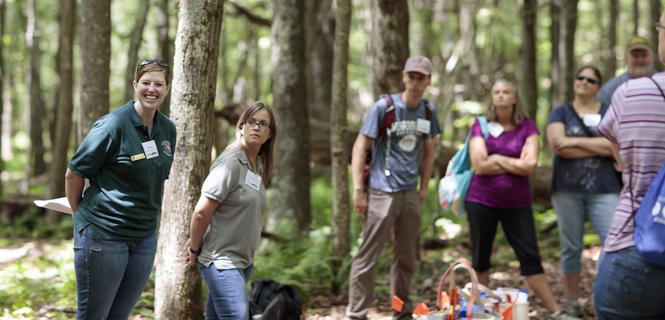 Two women teaching teachers in the forest.