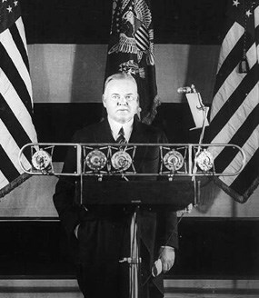 Herbert Hoover in front of microphones announcing Public Works program.