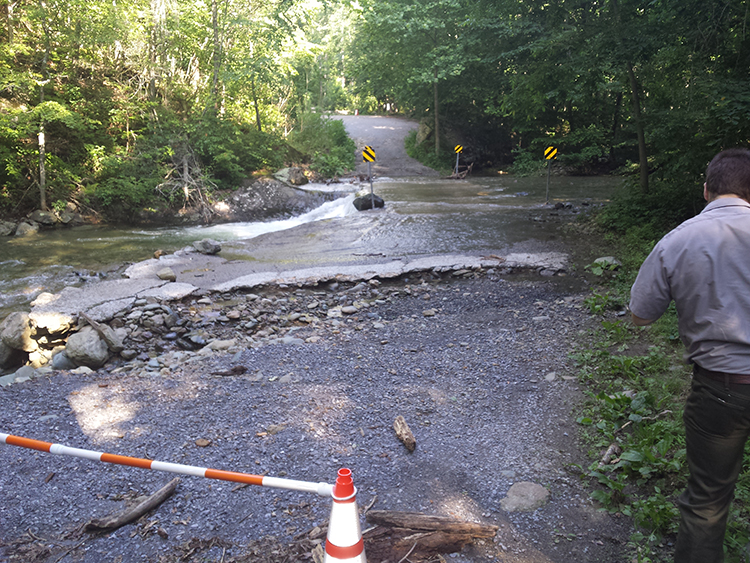 Flood waters pour over a bridge