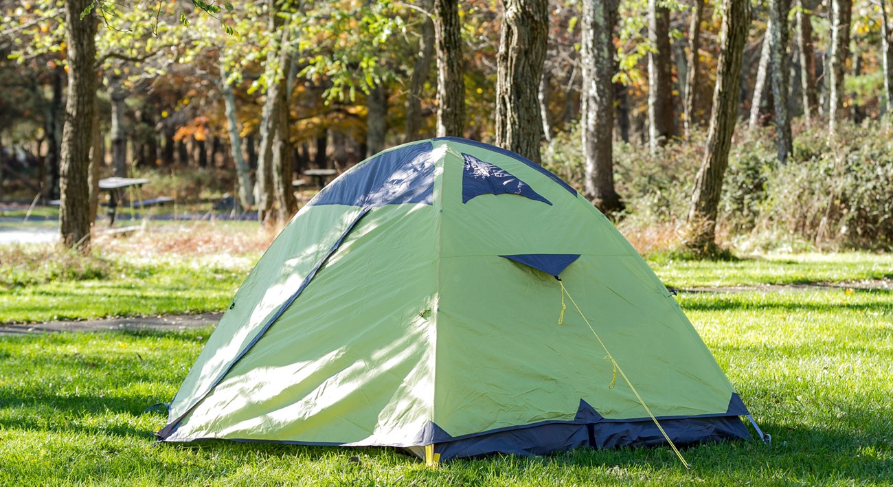 A tent is set up in a campground.