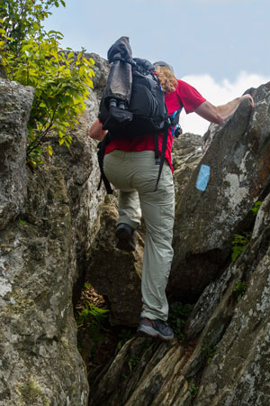 Hiker scaling rocks on the Bearfence rock scramble. Hiker scaling rocks on the Bearfence rock scramble.