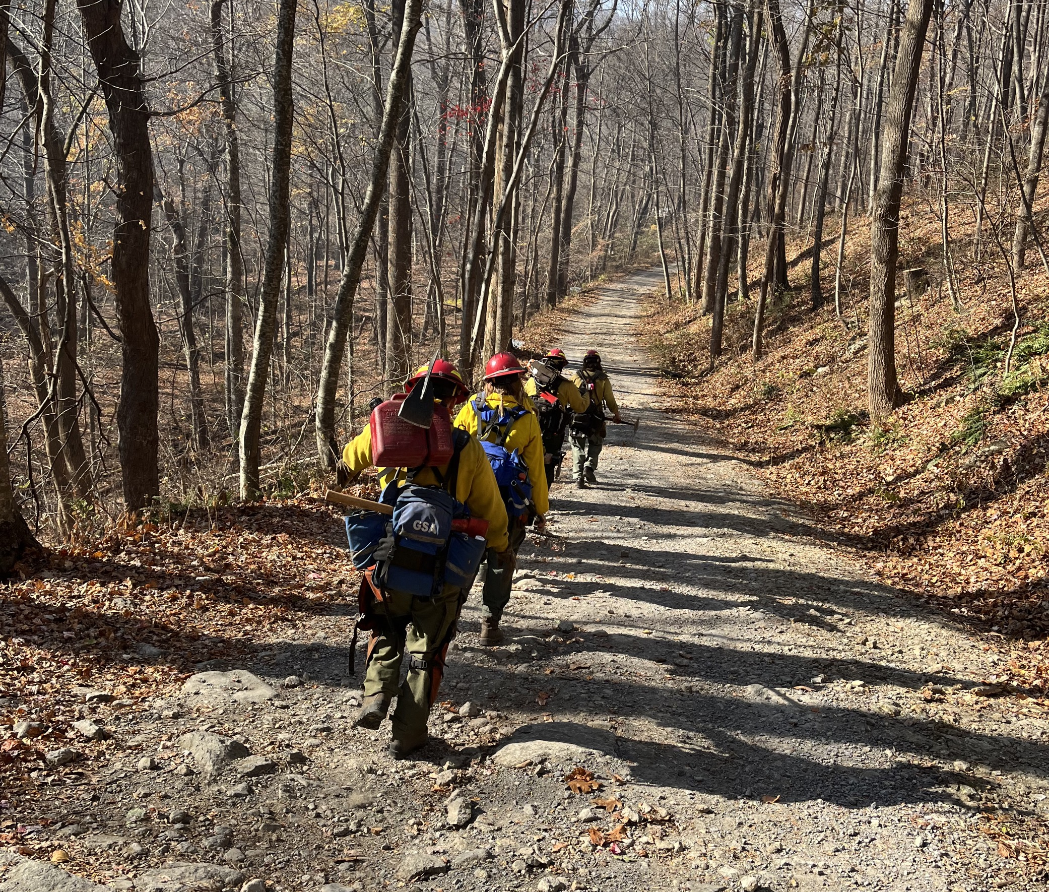 Firefighters traveling along a gravel road