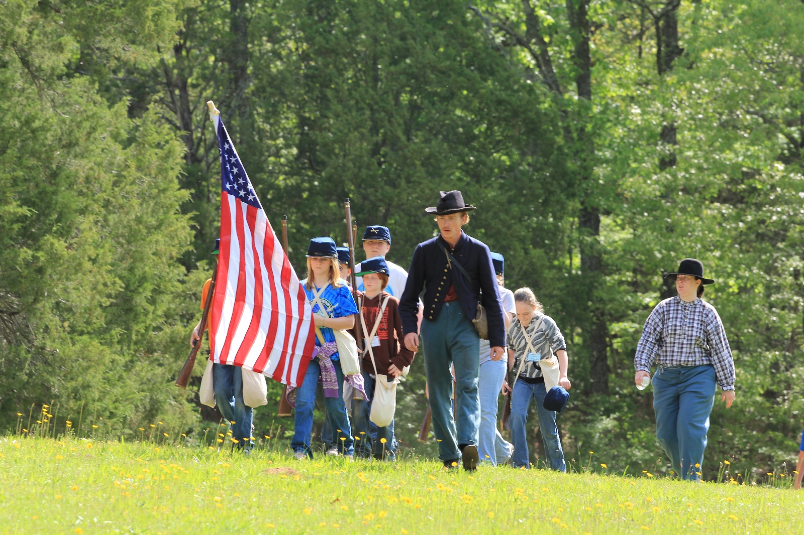 Kids march while carrying an American flag.