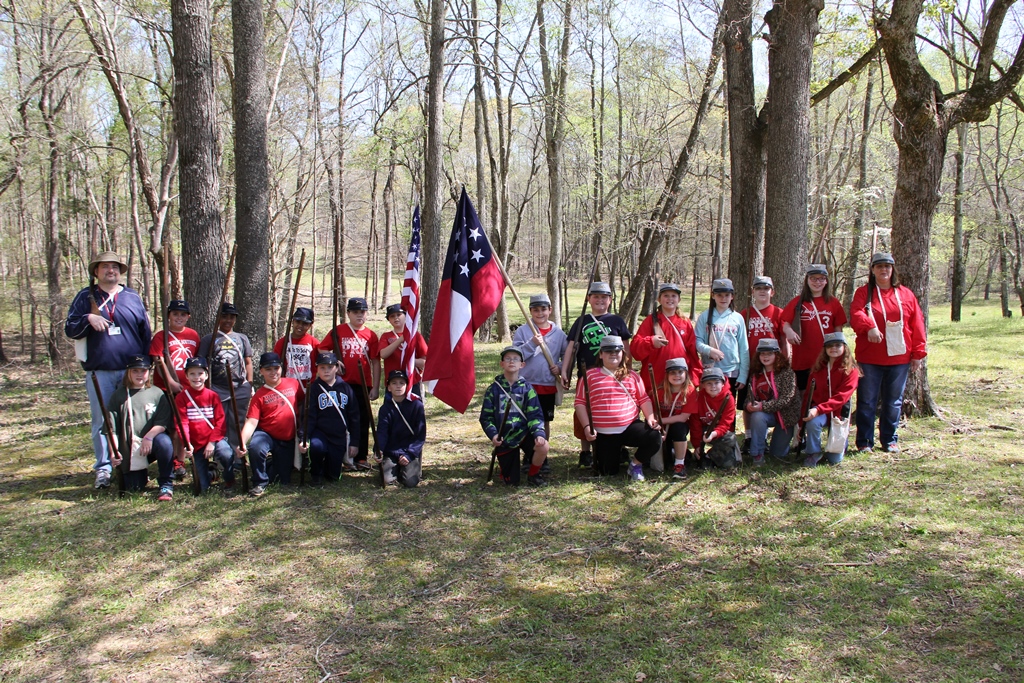 Kids posing holding flags and muskets