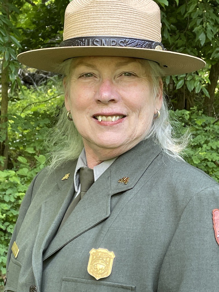 Supt. Catherine Bragaw Woman in park ranger uniform and ranger hat smiling.
