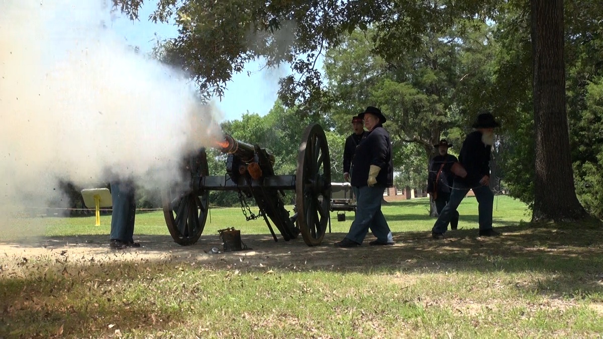 Living historians in blue uniforms fire a cannon