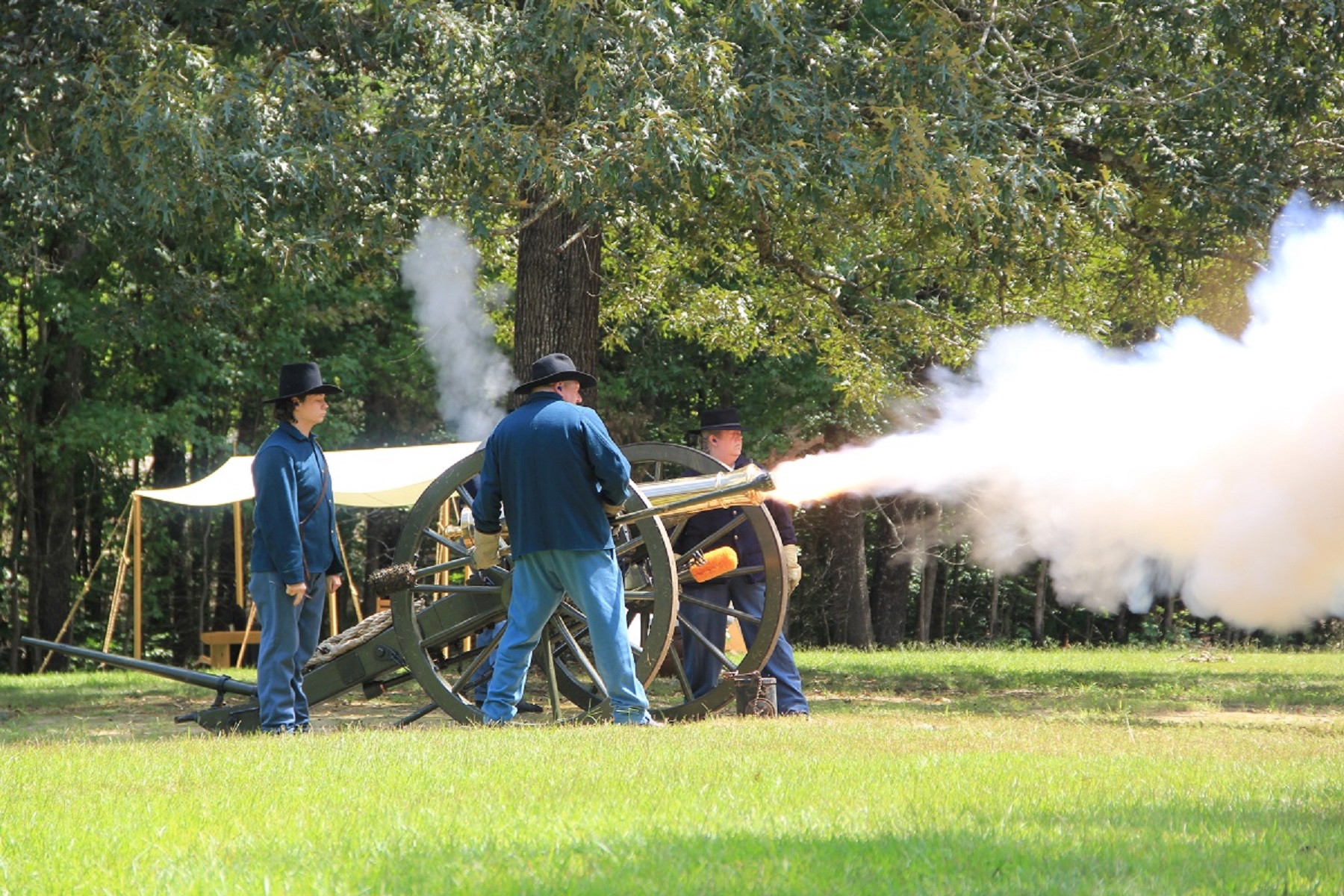 Living historians in blue uniforms fire a cannon