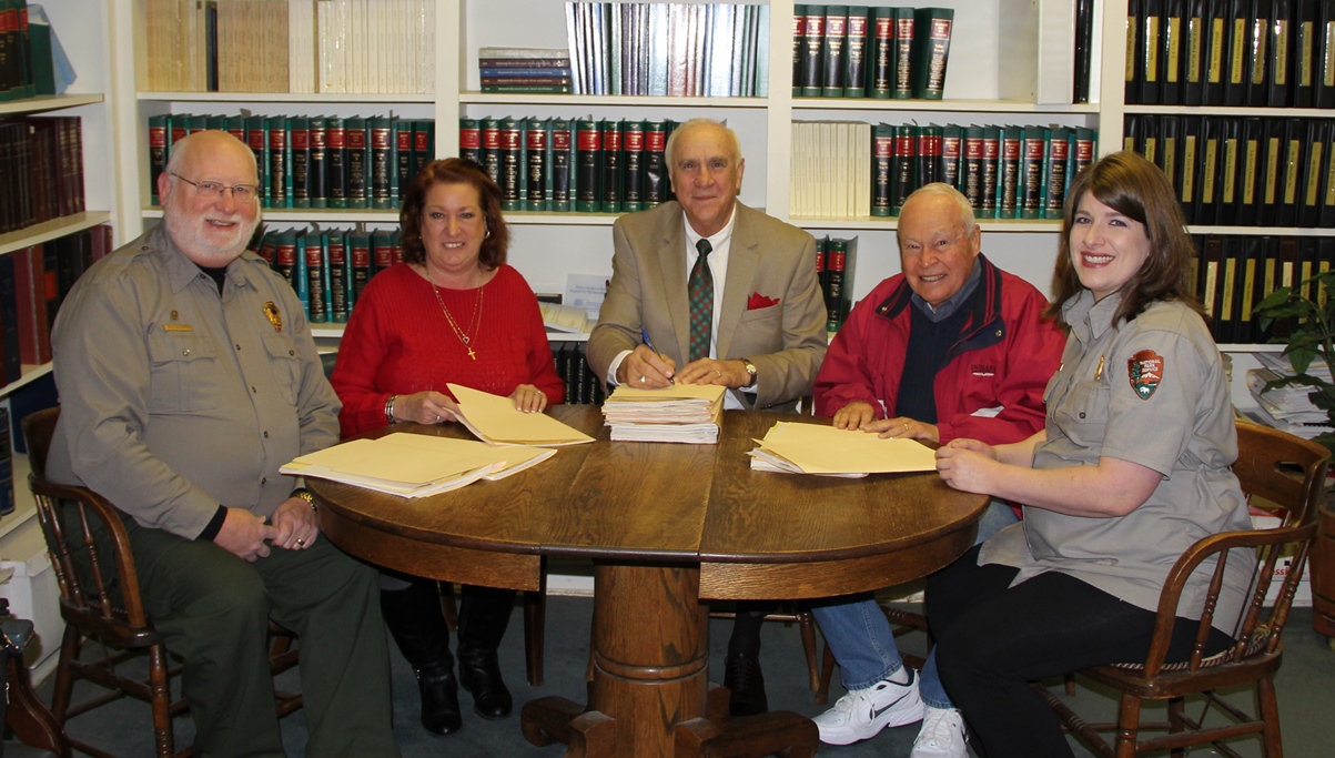 NPS staff and friends group sign the documents to transfer the land