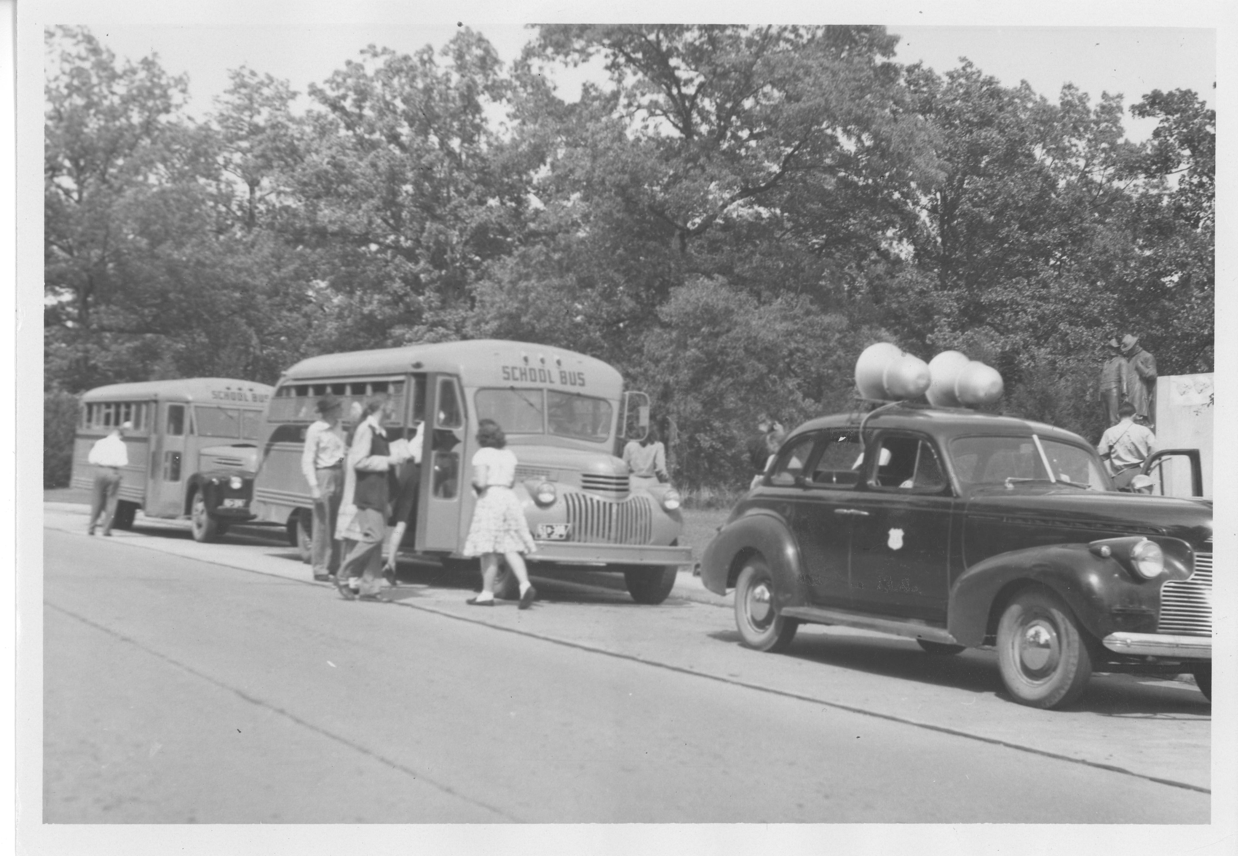 Historic image of a park vehicle and two school buses