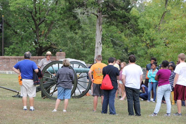 Park ranger discussing cannon with visitors