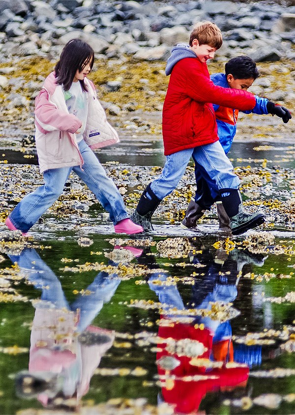 Three kids crossing the intertidal lands during low tide. Three kids crossing the intertidal lands during low tide.