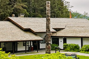 Visitor center building with a totem pole in the foreground.